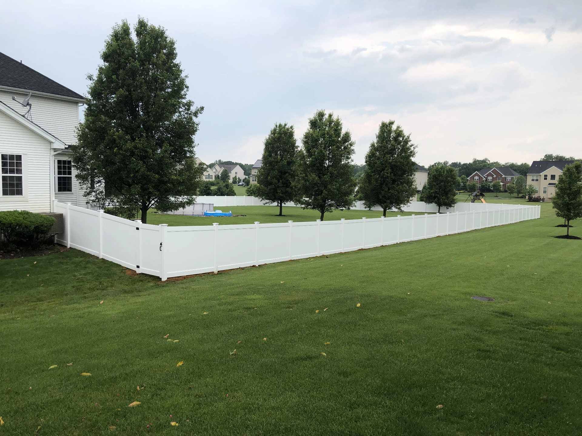 White vinyl semi-privacy fence enclosing a large residential backyard in New Jersey installed by Fred's Fence