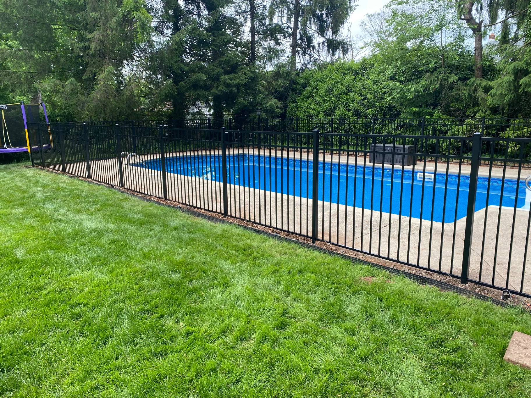 Black aluminum pool code-compliant fence around an in-ground pool in New Jersey by Fred's Fence