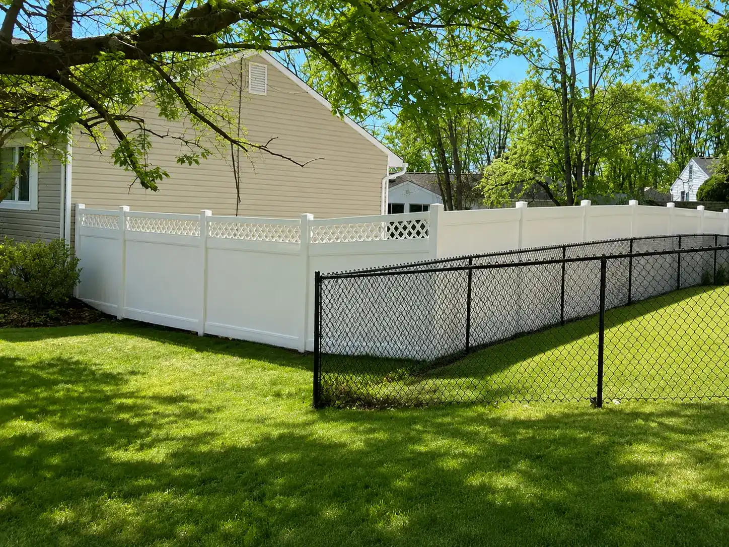 White vinyl privacy fence and black chain link fence in a South Brunswick, NJ backyard
